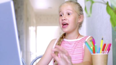 A young girl works excitedly on her computer
