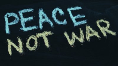'Peace not war' written in chalk on a black board